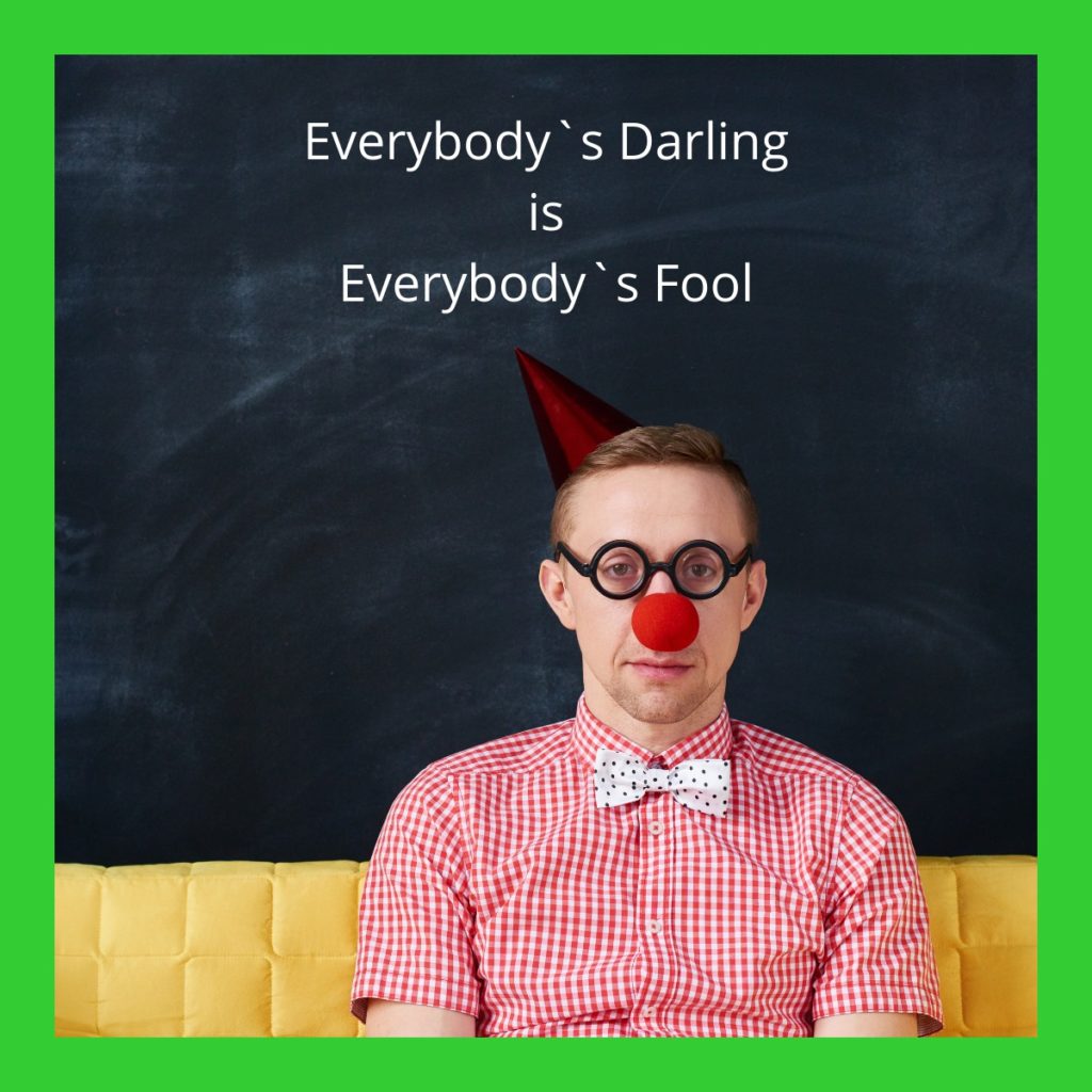 Everybody`s Darling is Everybody`s Fool. Im Bild ein Mann mit Clownsnase und Papphütchen auf dem Kopf. Text: Everbody`s Darling is Everbody`s Fool.