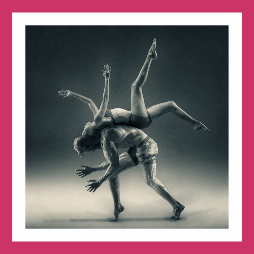Künstlersozialkasse. Im Bild zwei Künstler bei einer sportlichen Hebefigur: Frau rollt sich über den Rücken des Mannes im Salto ab.